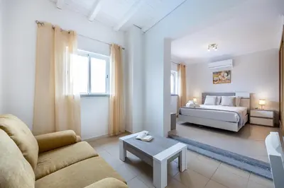 a living room with a bed and a couch and a table at IM On Casa Mar e SOL in Lagos