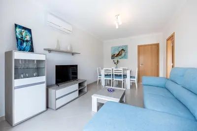 a living room with a blue couch and a table at IM On Casa Mar e SOL in Lagos