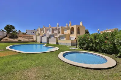 two swimming pools in a yard in front of a building at IM On Casa Mar e SOL in Lagos