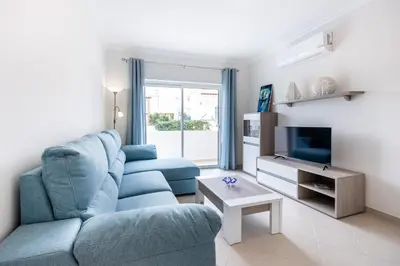 a living room with a blue couch and a tv at IM On Casa Mar e SOL in Lagos