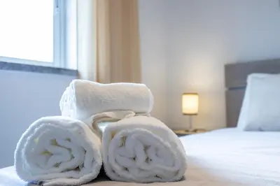 a pile of towels sitting on top of a bed at IM On Casa Mar e SOL in Lagos