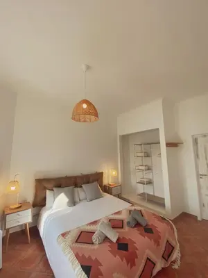 a bedroom with a large bed with two towels on it at The Lighthouse Hostel Arrifana in Aljezur
