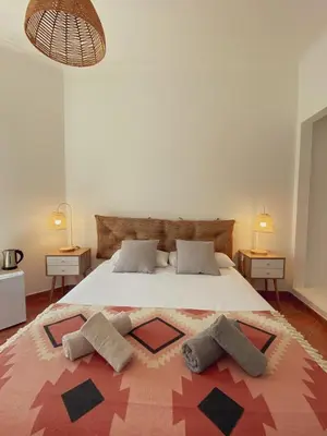 two beds in a bedroom with two lamps and a ceiling at The Lighthouse Hostel Arrifana in Aljezur