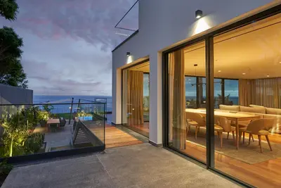 a house with a balcony with a table and chairs at La Villa at The Cliff Bay - PortoBay in Funchal