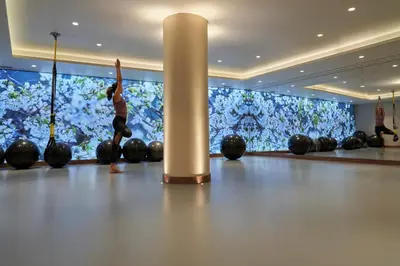 a woman is doing a pose in a gym at La Villa at The Cliff Bay - PortoBay in Funchal