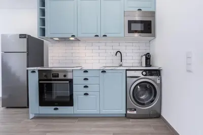 a kitchen with a refrigerator and a washing machine at Casa Monte Salema in Vila do Bispo