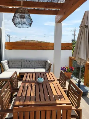 a patio with a wooden table and chairs at Casa Monte Salema in Vila do Bispo