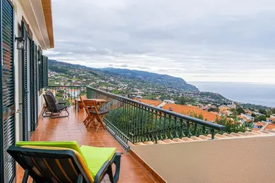 a balcony with chairs and a view of the city at Namastê House I in Relógio do Poiso