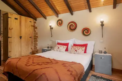 a bedroom with a large bed with red pillows at Casa de Campo Arco de São Jorge by An Island Apart in Santana