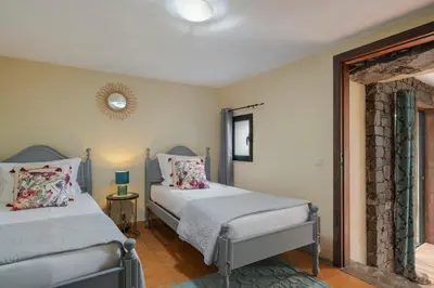 a bedroom with two beds and a mirror at Casa de Campo Arco de São Jorge by An Island Apart in Santana