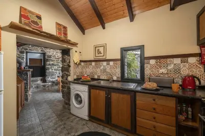 a kitchen with a washing machine and a sink at Casa de Campo Arco de São Jorge by An Island Apart in Santana