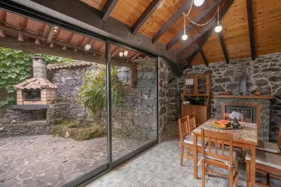 an outdoor kitchen with a table and a fireplace at Casa de Campo Arco de São Jorge by An Island Apart in Santana