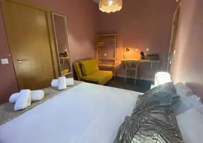 a bedroom with a white bed and a yellow chair at Porto Santo Destination in Porto Santo