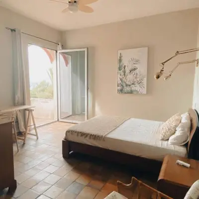 a bedroom with a bed and a sliding glass door at Porto Santo Destination in Porto Santo