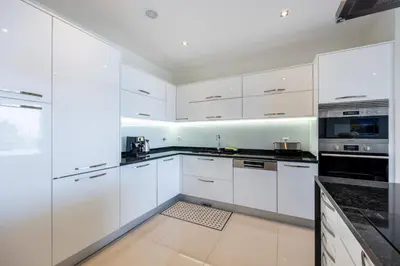 a white kitchen with white cabinets and appliances at CoolHouses Algarve Lagos, 3 Bed modern Flat, outdoor & Indoor pools, Gym, Amor à Vida in Lagos
