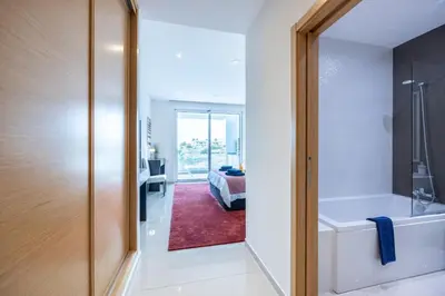 a bathroom with a bath tub and a bedroom at CoolHouses Algarve Lagos, 3 Bed modern Flat, outdoor & Indoor pools, Gym, Amor à Vida in Lagos