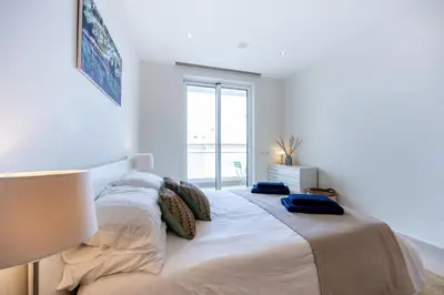 a white bedroom with a large bed with a window at CoolHouses Algarve Lagos, 3 Bed modern Flat, outdoor & Indoor pools, Gym, Amor à Vida in Lagos