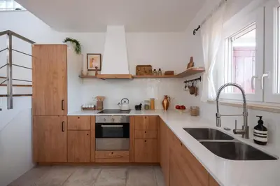 a kitchen with wooden cabinets and a sink at Casa Almargens in Aljezur by Lisbeyond in Bordeira