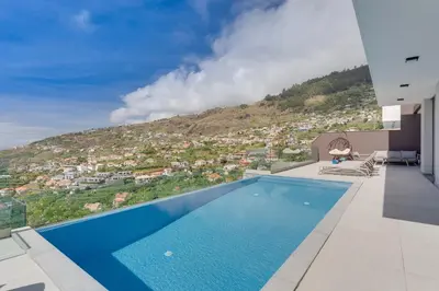 a swimming pool with a view of a city at Luxury Villa Bianca by Holiday Rental Madeira in Arco da Calheta