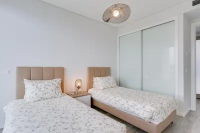 two beds in a room with white walls at Luxury Villa Bianca by Holiday Rental Madeira in Arco da Calheta