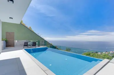 a swimming pool in a house with a view of the ocean at Luxury Villa Bianca by Holiday Rental Madeira in Arco da Calheta
