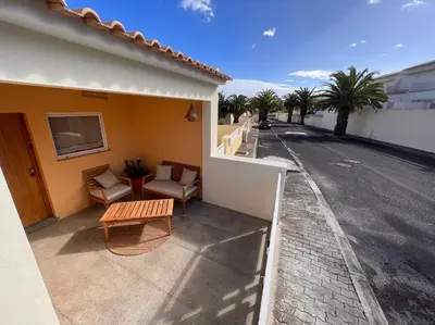 a balcony of a house with a bench and a street at Casa da Pedreira in Porto Santo