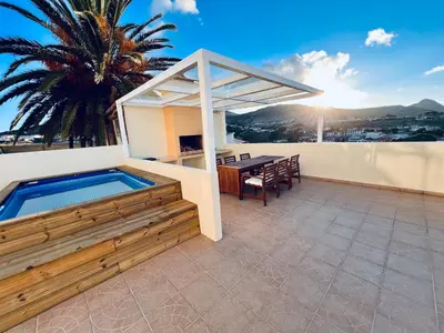 a patio with a table and a swimming pool at Casa da Pedreira in Porto Santo