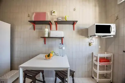 a small kitchen with a table and a microwave at Cabo de Sagres -2 bedroom apartment in Sagres