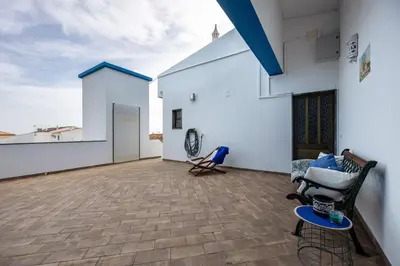 a large patio with white walls and a blue roof at Cabo de Sagres -2 bedroom apartment in Sagres