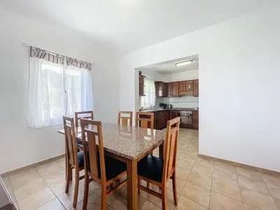 a kitchen and dining room with a table and chairs at Casa do Romaninho in Porto da Cruz