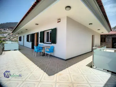 a balcony of a house with a table and chairs at Yohanna's accommodation in Campanário