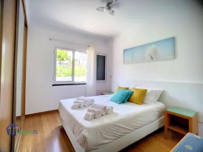a bedroom with a large white bed with towels on it at Yohanna's accommodation in Campanário