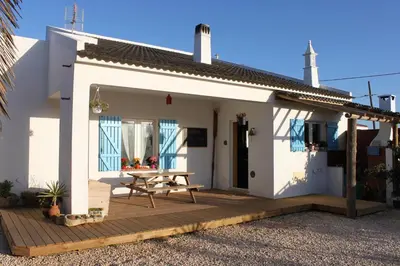 a small white house with a wooden deck at PuraVida Divehouse in Sagres