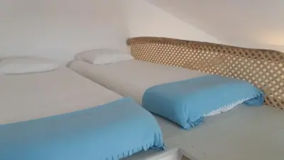 a room with two beds with blue pillows at PuraVida Divehouse in Sagres