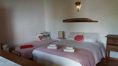 a bedroom with two beds with pink and white sheets at PuraVida Divehouse in Sagres