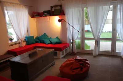 a living room with a couch in a room with windows at PuraVida Divehouse in Sagres