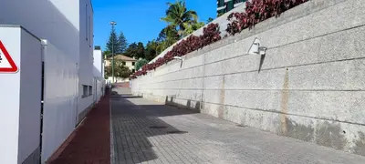 an empty sidewalk next to a wall with flowers on it at Lindas Holiday Apartment in Funchal