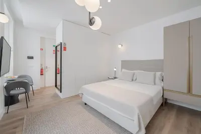 a white bedroom with a white bed and a desk at FAA Belas Artes by An Island Apart in Funchal