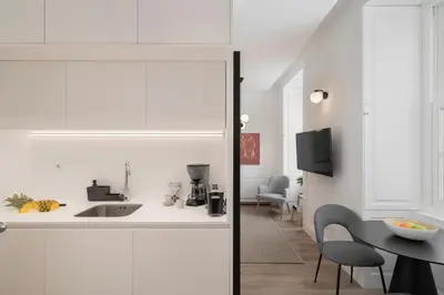 a kitchen and dining room with white cabinets and a table at FAA Belas Artes by An Island Apart in Funchal