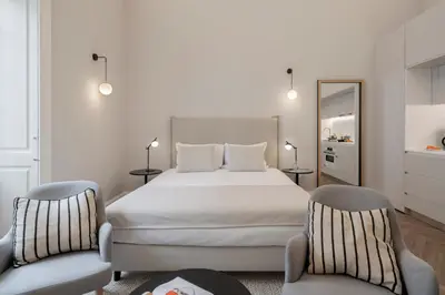 a bedroom with a large bed and two chairs at FAA Belas Artes by An Island Apart in Funchal