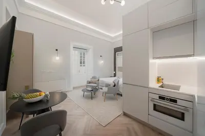 a kitchen and living room with a table and chairs at FAA Belas Artes by An Island Apart in Funchal