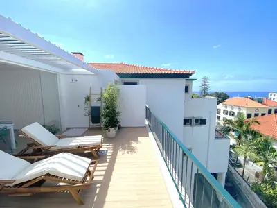 a dining room with a glass table and chairs at Madeira Precious Penthouse in Funchal