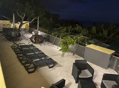 a group of chairs and tables on a patio at night at Quintinha dos Reis in Funchal