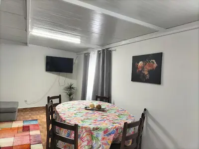 a dining room with a table and a television at Quintinha dos Reis in Funchal