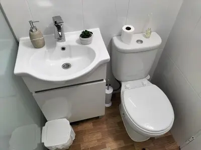 a white bathroom with a toilet and a sink at Quintinha dos Reis in Funchal