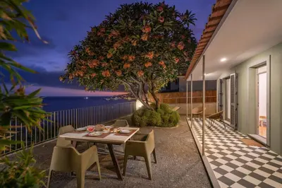 a table and chairs on a balcony with a tree at Lazareto Mar by An Island Apart in Funchal