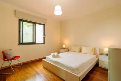 a bedroom with a bed and a red chair at Ponta do Sol Amazing 3 Bedroom Apartment in Ponta do Sol