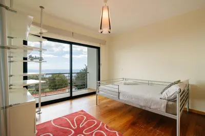 a bedroom with a bed and a large window at Ponta do Sol Amazing 3 Bedroom Apartment in Ponta do Sol