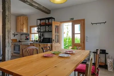 a kitchen with a wooden table with plates on it at O Lagar do Avô, a Home in Madeira in São Jorge