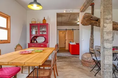 a dining room with a wooden table and a red cabinet at O Lagar do Avô, a Home in Madeira in São Jorge